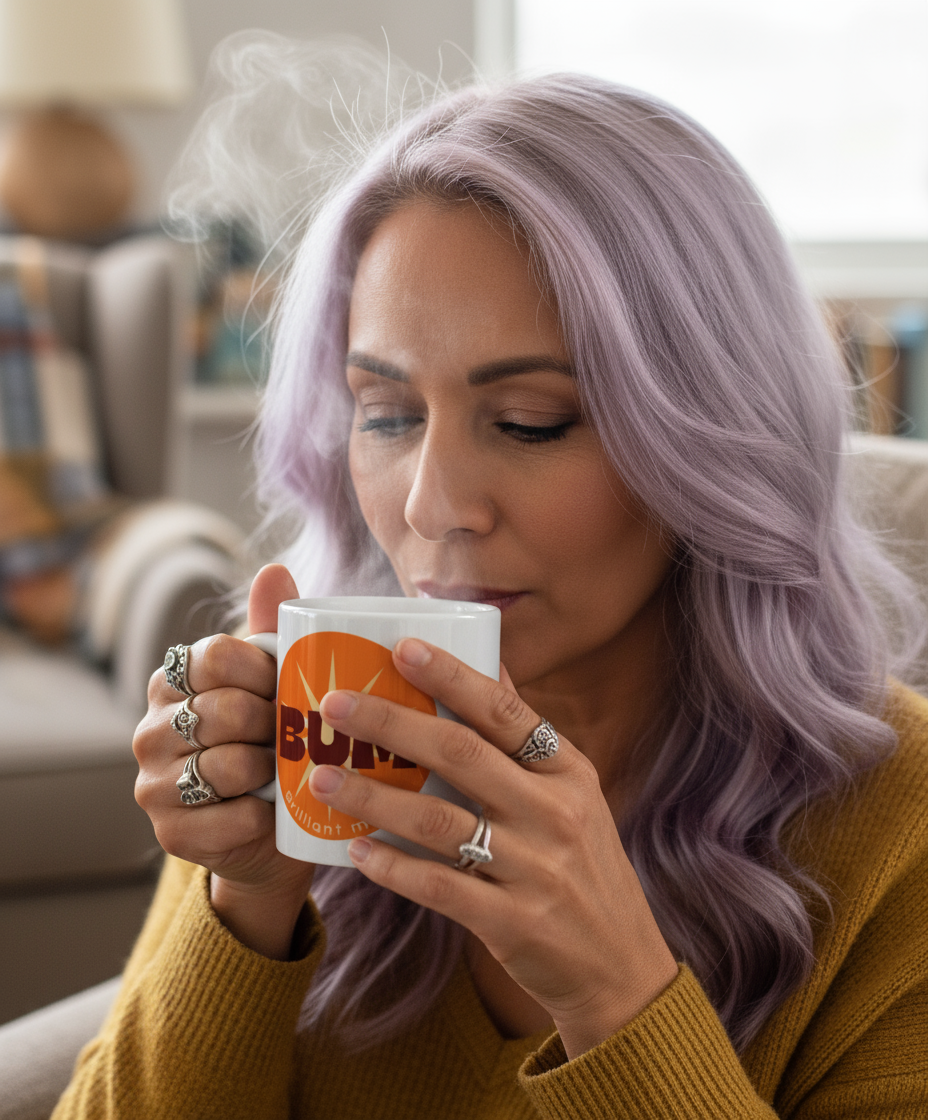 Woman with purple hair drinking from a mug with 'Bum' branding in a cozy living room.